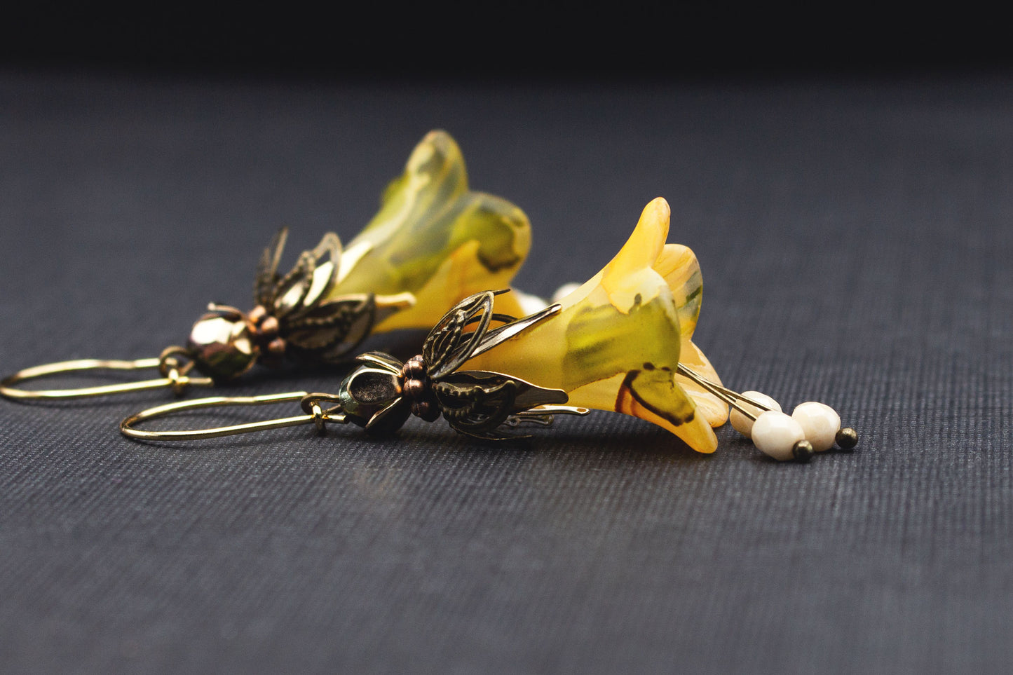 Detailansicht handbemalter Blüten in Creme, Gelb und Olivgrün mit goldfarbenen Elementen