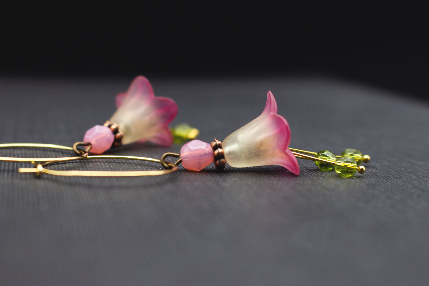 Seitenansicht goldfarbene Creolen mit gelb-fuchsiafarbener Blüte und Glasperlen