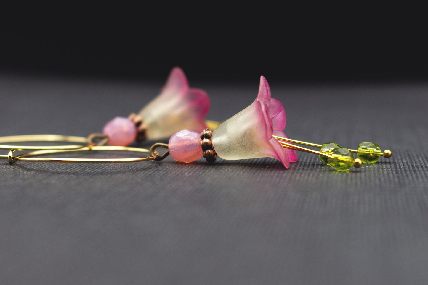 Detail goldfarbene Blütenohrringe mit Glasperlen in Olivgrün und Rosa