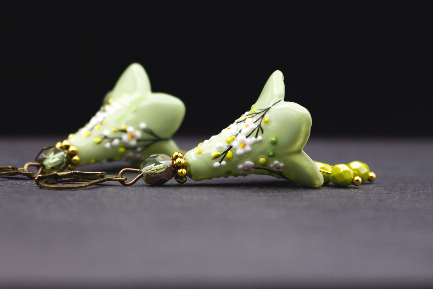 Zarte Ohrringe in Grün Weiß mit floralen Details und handbemalter Blüte