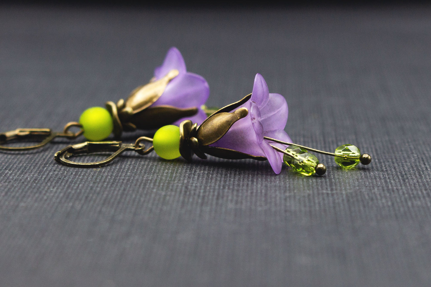 Seitliche Ansicht romantischer Glockenblumen-Ohrringe in Lila und Olivgrün mit Polaris-Perle
