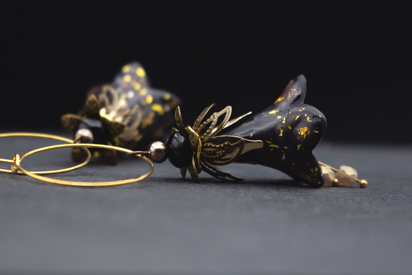 Elegante Blütenohrringe Schwarz Gold – Ohrschmuck mit funkelndem Konfetti-Effekt