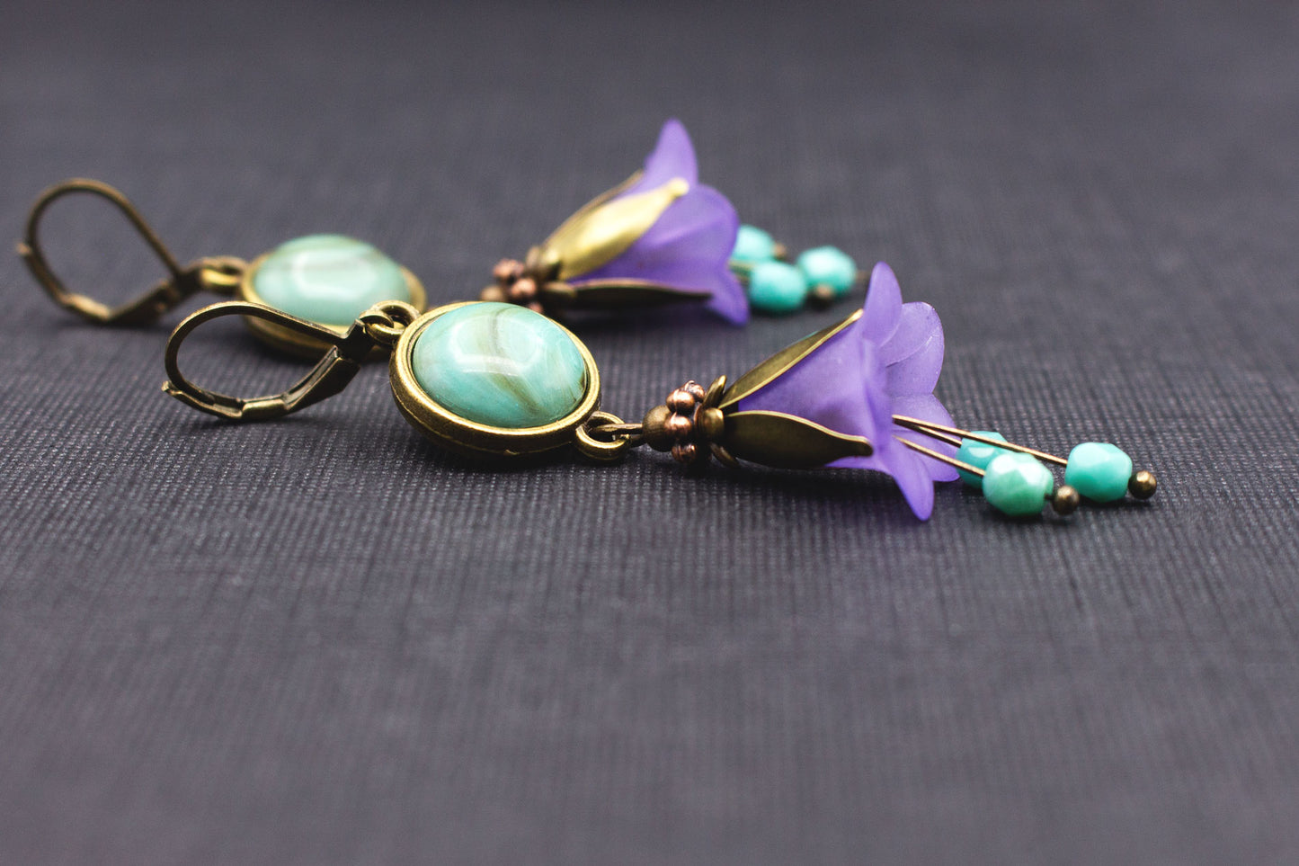 Seitliche Ansicht romantischer Glockenblumen-Ohrringe in Türkis und Lila mit Cabochon-Perlen