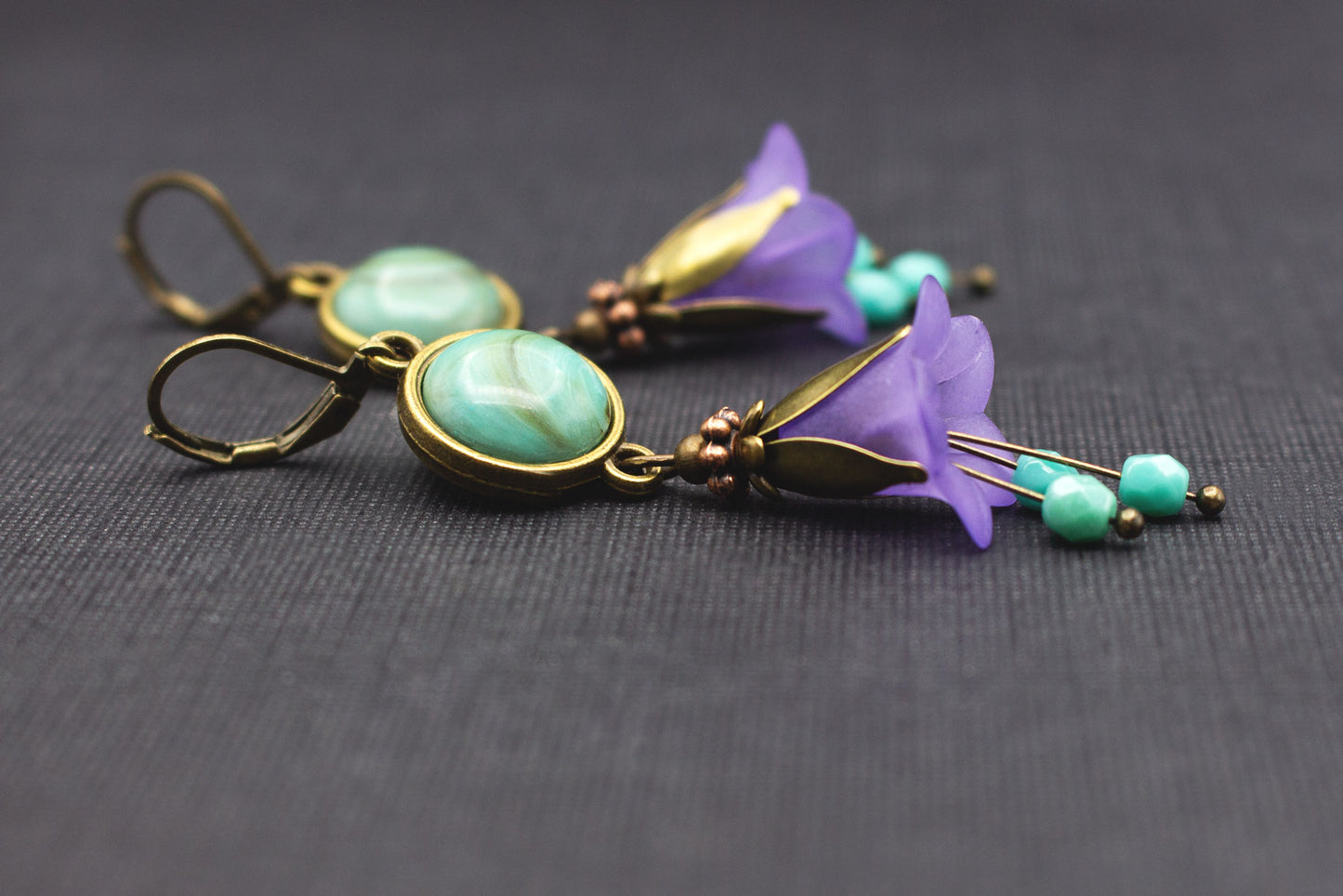 Detailaufnahme der Cabochon-Perlen und Acryl-Glockenblumen in Türkis und Lila mit Glasperlen