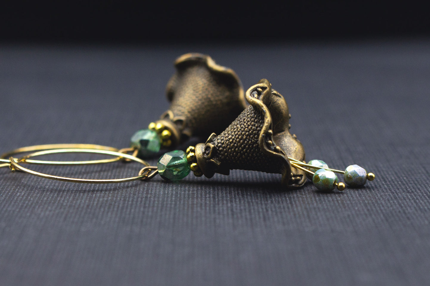 Creolen-Ohrringe mit Metallblüten in Antik-Bronze und grünen Perlen
