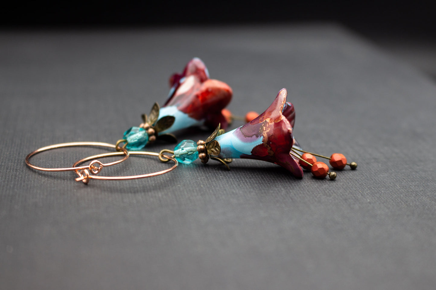 Handbemalte Blütenohrringe in Blau und Rot an Creolen – romantischer Schmuck
