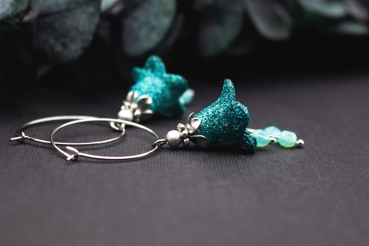 Lange Creolen Ohrringe mit Türkisglitzer, Glasperlen und kühler Silberoptik, handgefertigtes Schmuckdesign mit lebendiger Lichtwirkung