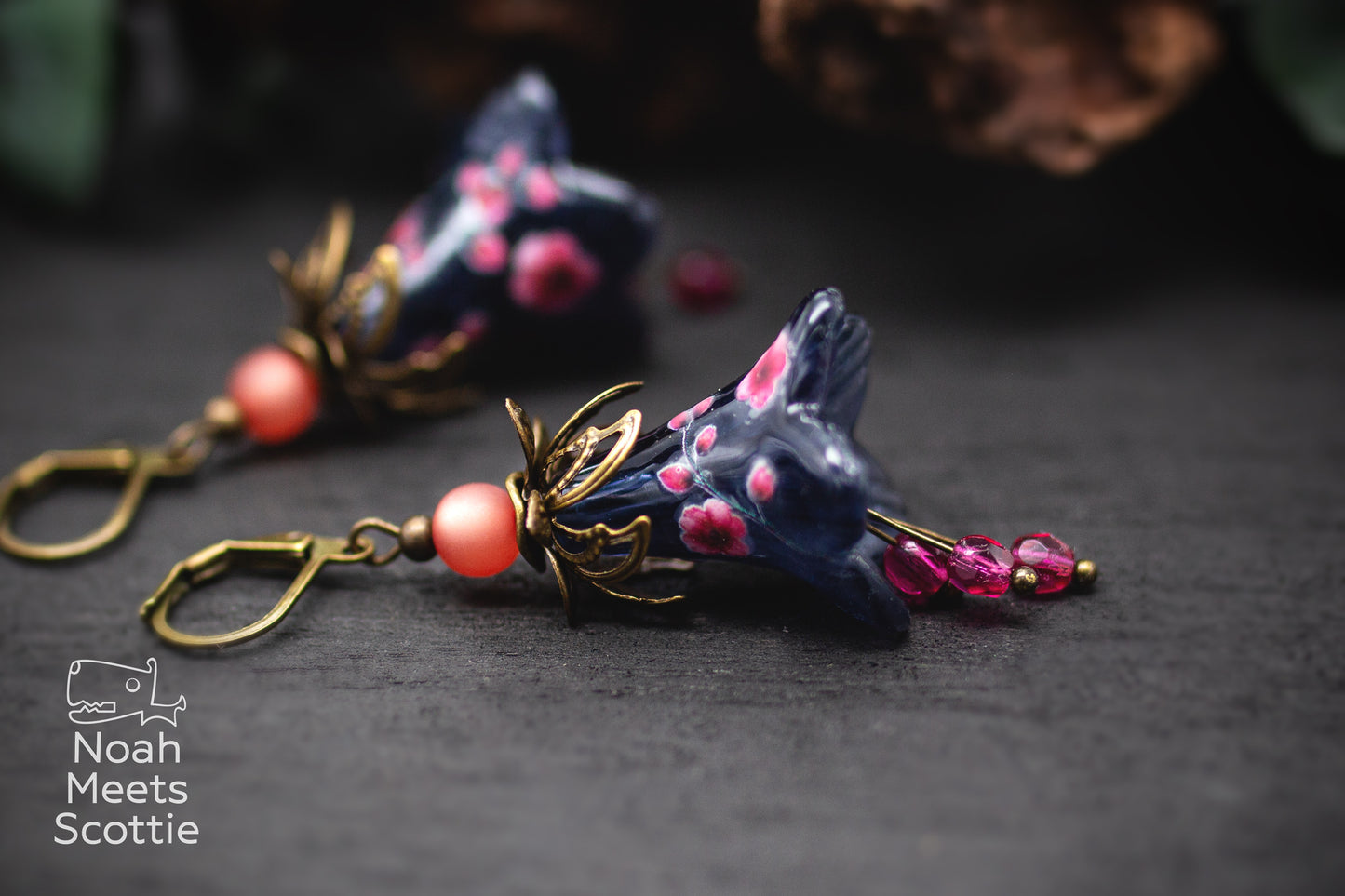 Nachtblaue Blütenohrringe mit rosa Kirschblüten, altrosa Polarisperlen und bronzefarbenen Metallelementen.