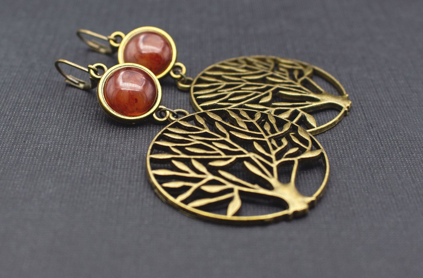 Seitenansicht von Antik-Bronze-Ohrringen mit Baum-Anhänger und Cabochon in Bernsteinbraun