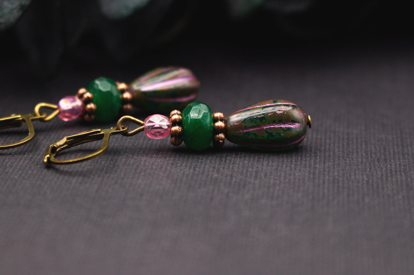 Elegante Ohrringe mit Glasperlen in Grün und Rosa und warmen Metalltönen, ruhiges Design