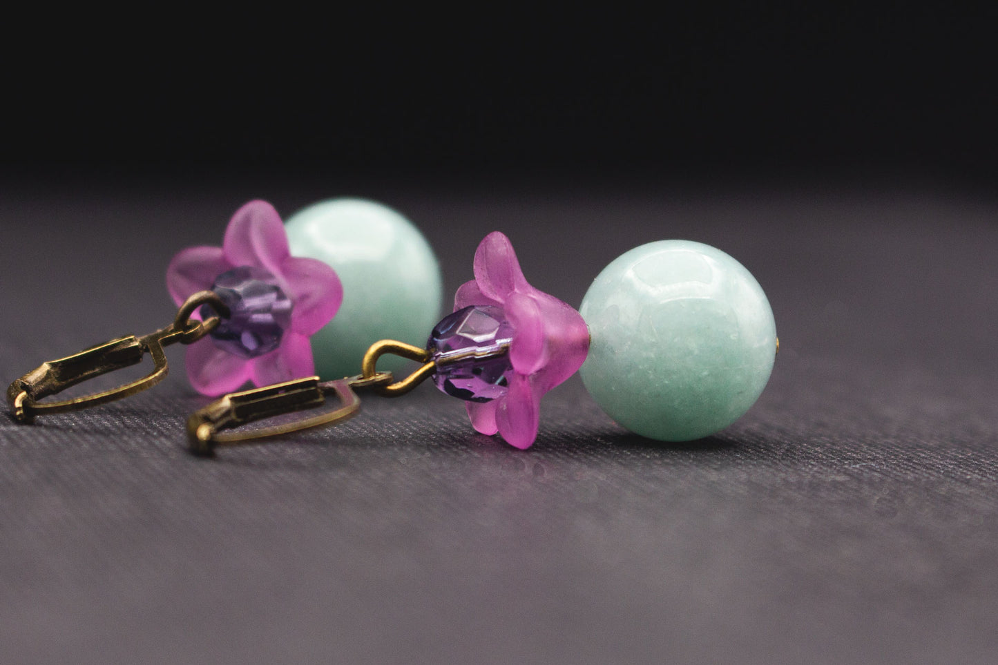Detailansicht elegante Ohrringe mit hellblauen Glasperlen und violetten Blüten