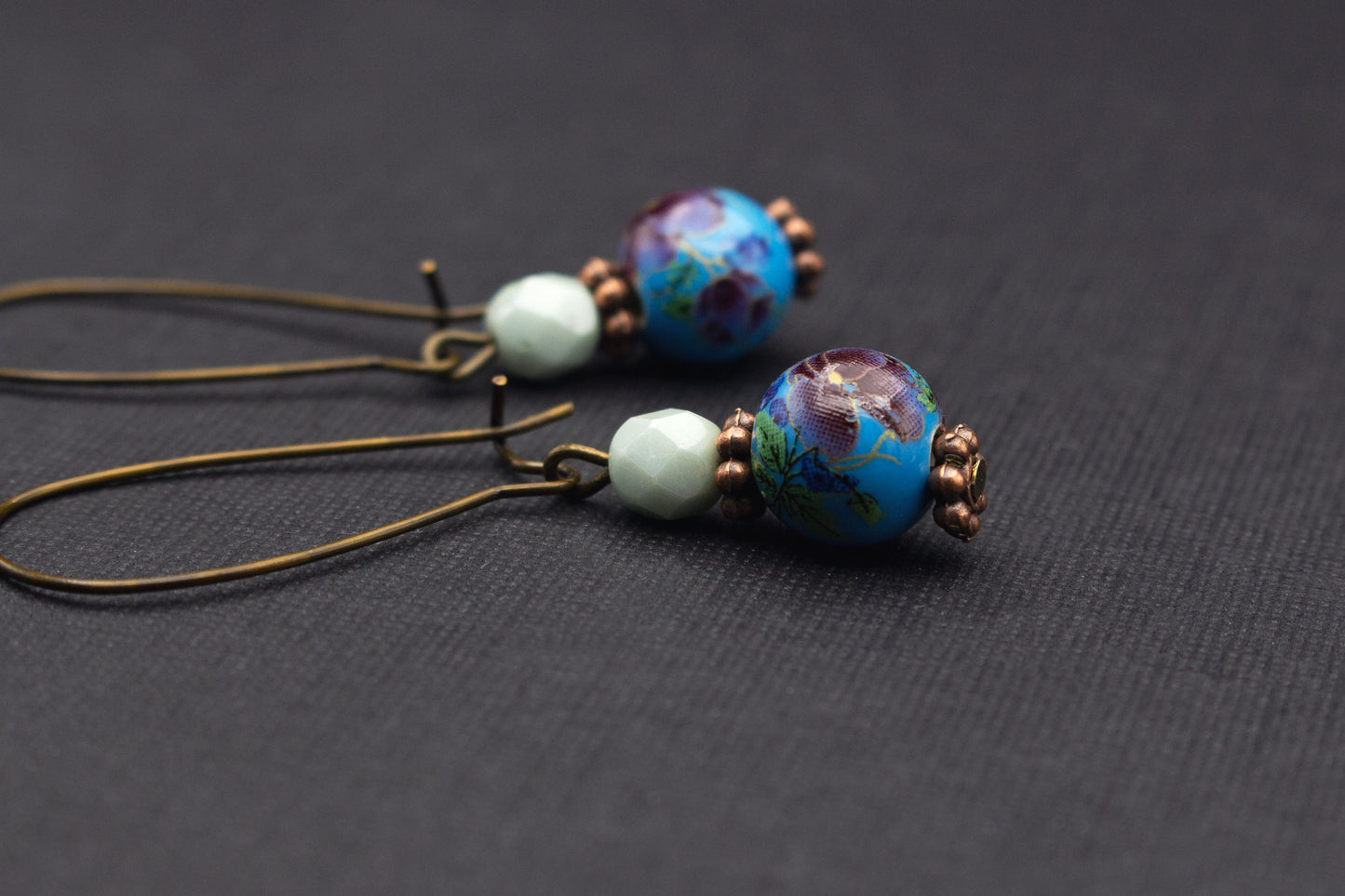 Detailaufnahme der Keramikperlen mit Kirschblütenmotiv in Blau, Lila und Mint