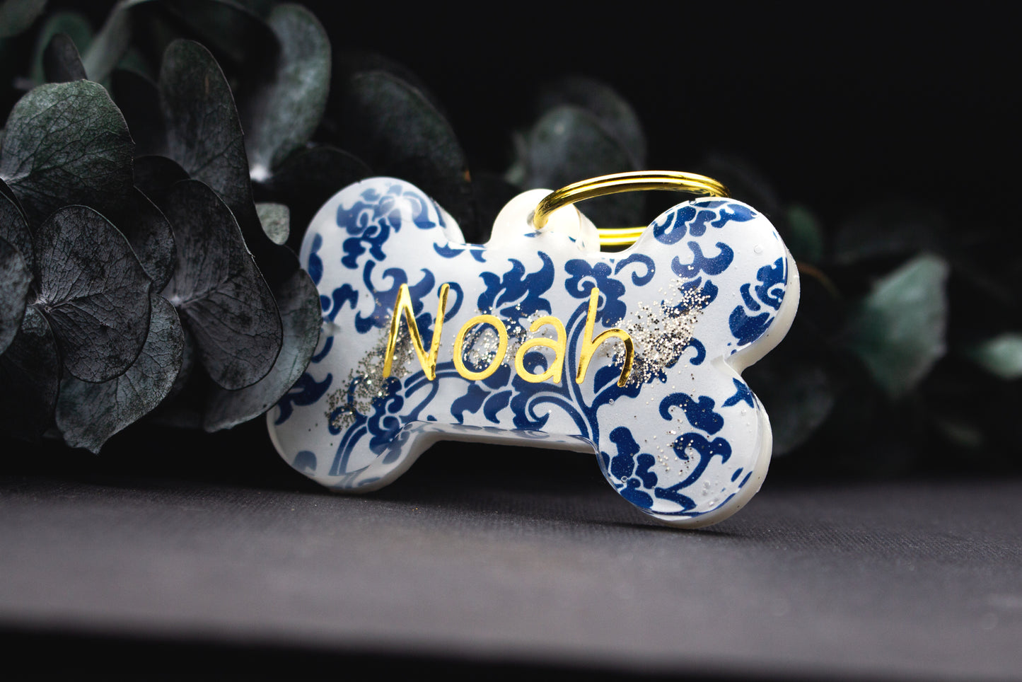 Detailaufnahme der Hundemarke MARAZUR mit blau-weißem Muster und goldenem Schriftzug, Resin versiegelt