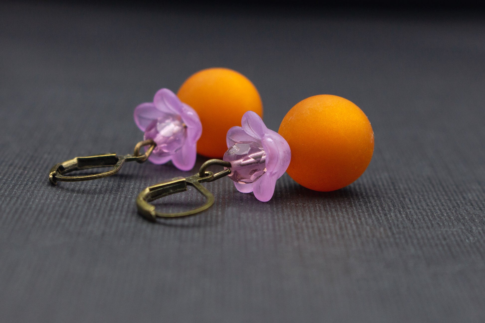 Nahaufnahme einer fliederfarbenen Blüte kombiniert mit hellbrauner Polaris-Perle, eleganter Ohrschmuck