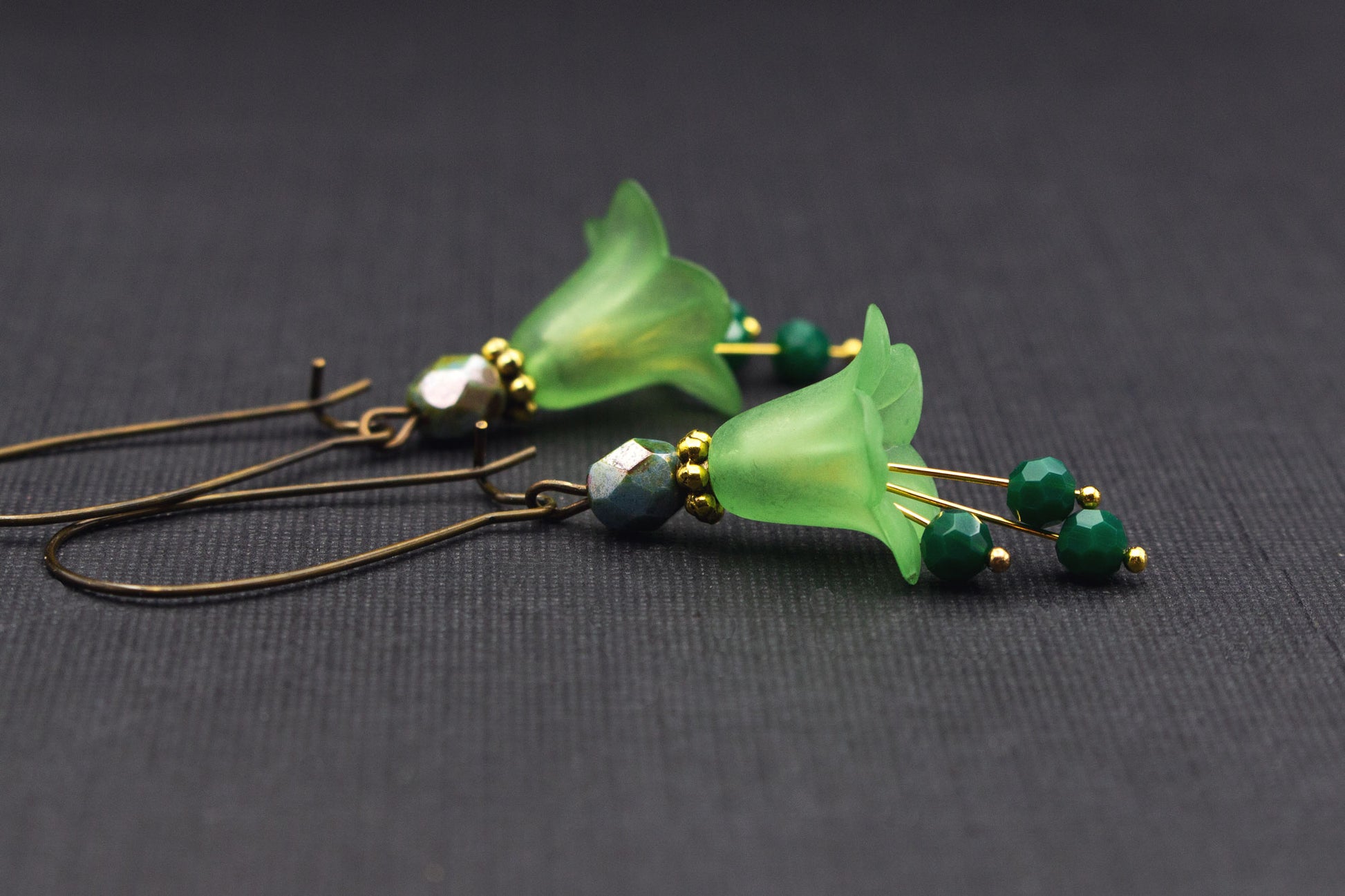 Detailansicht florale Ohrringe mit lindgrünen Acrylblüten und dunkelgrünen Glasperlen, eleganter Schmuck