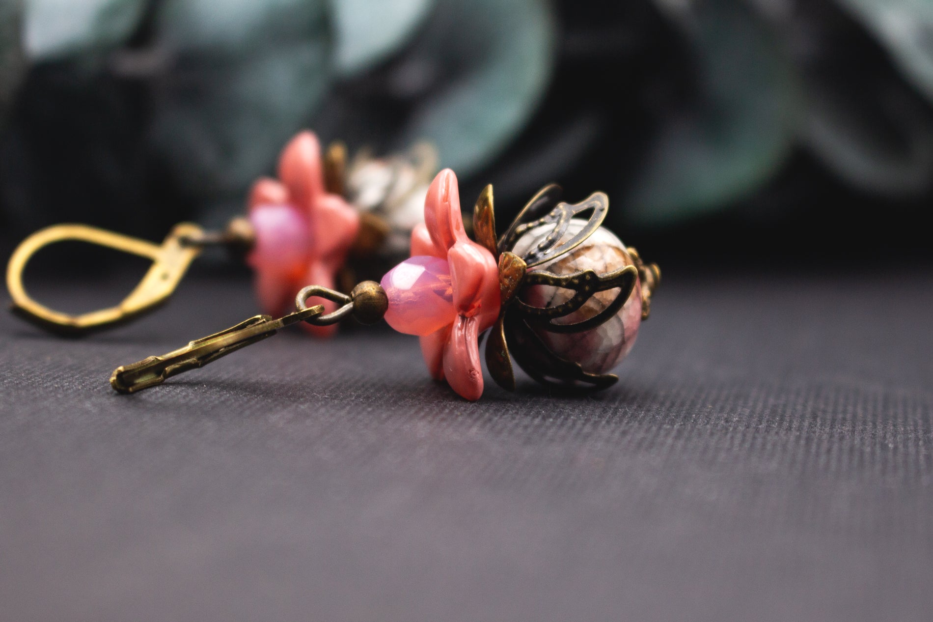 Apricot-Rosé Blumenohrringe mit facettierten Perlen und bronzener Blütenkappe – eleganter floraler Ohrhänger für stilvolle Outfits.