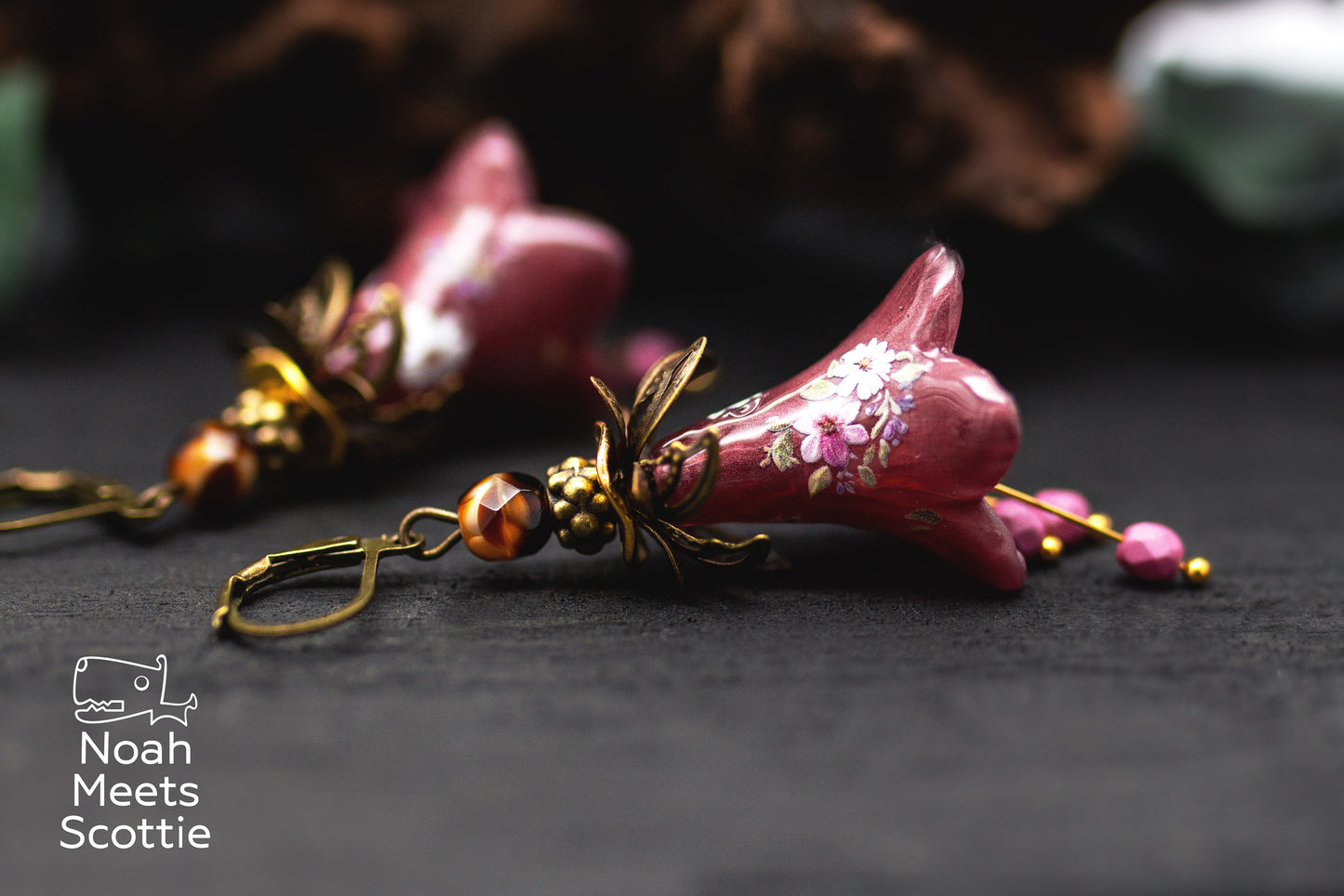 Handbemalte Blütenohrringe in Aubergine und Lila mit floralen Verzierungen und Glasperlen.