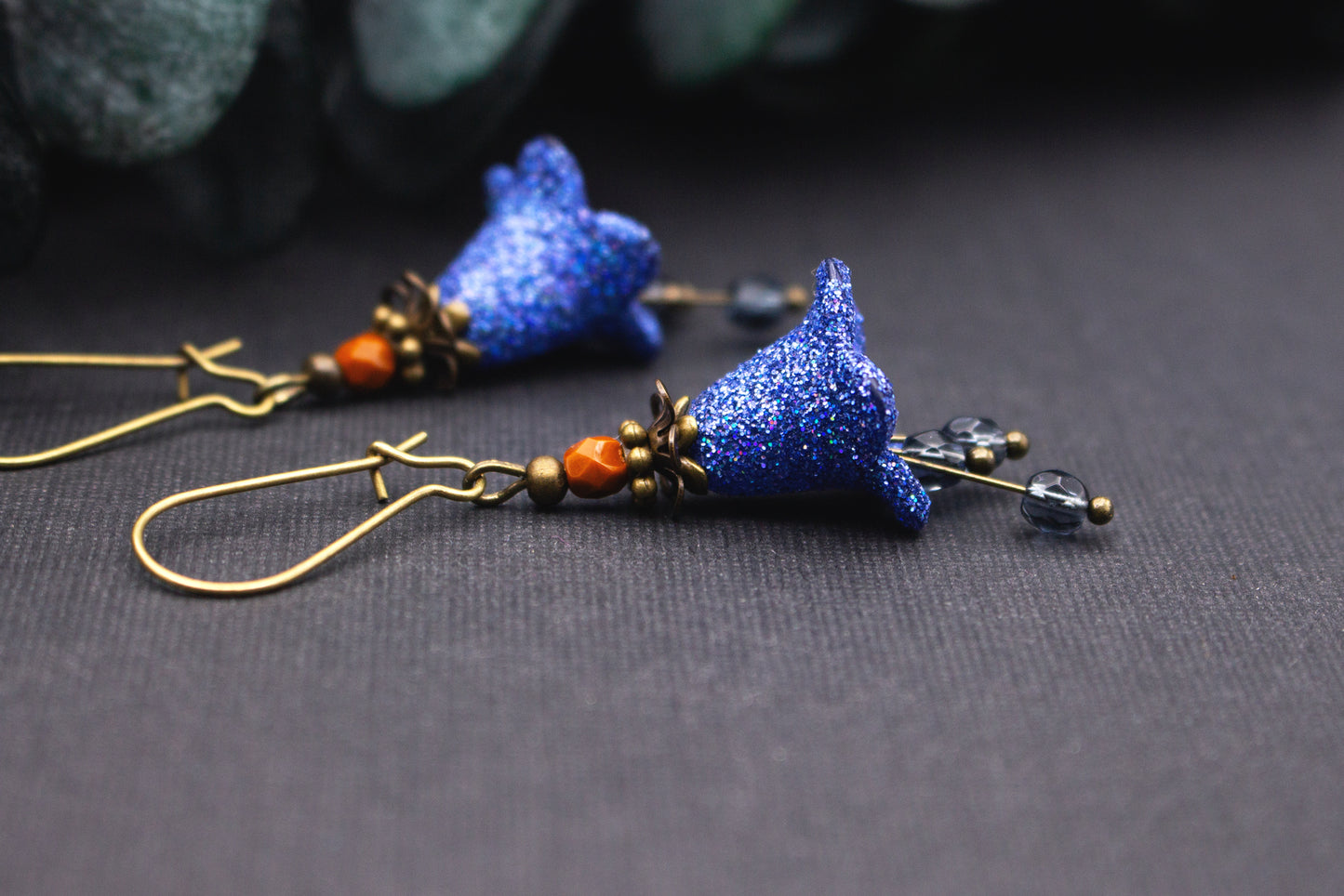 Detailaufnahme blauer Glitzer-Blütenohrringe mit strukturierter Oberfläche aus Acryl im Vintage Design