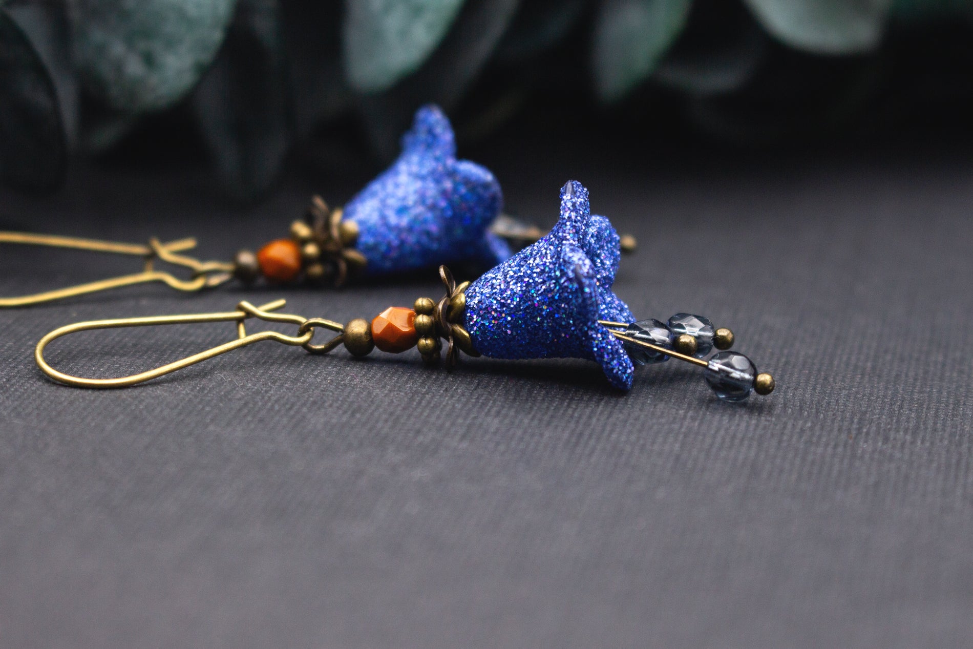 Handgefertigte Blütenohrringe in Blau mit Glitzer, Glasperlen und bronzenen Metallelementen