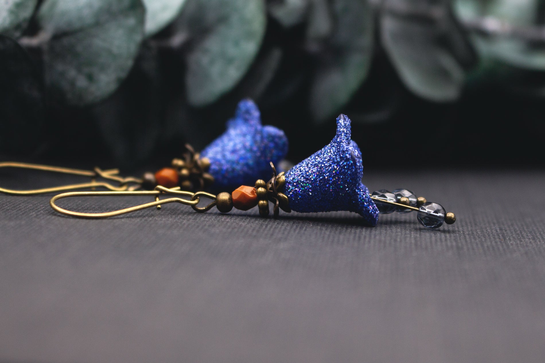 Blau glitzernde Blütenohrringe aus Acryl mit Glasperlen und warmem Metallton, handgefertigt