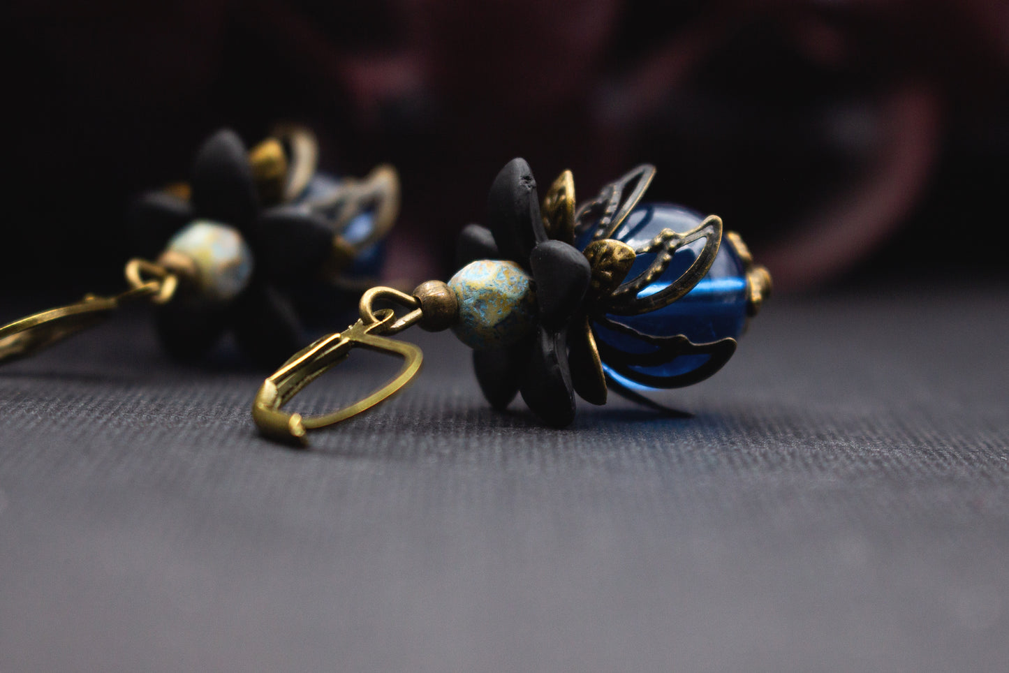Tiefe Blau-Schwarz-Ohrringe mit marmorierter Türkisperle und bronzefarbenen Details – ausdrucksstarker botanischer Vintage-Ohrschmuck.