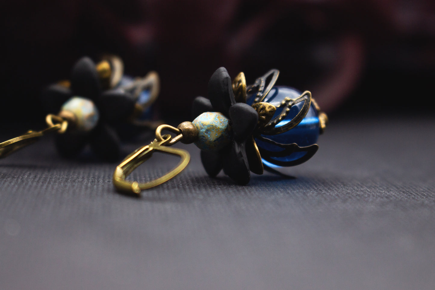 Vintage-Blumenohrringe in Blau und Schwarz mit metallischer Blütenkappe und Türkisdetail – elegantes Accessoire für Abendmode.