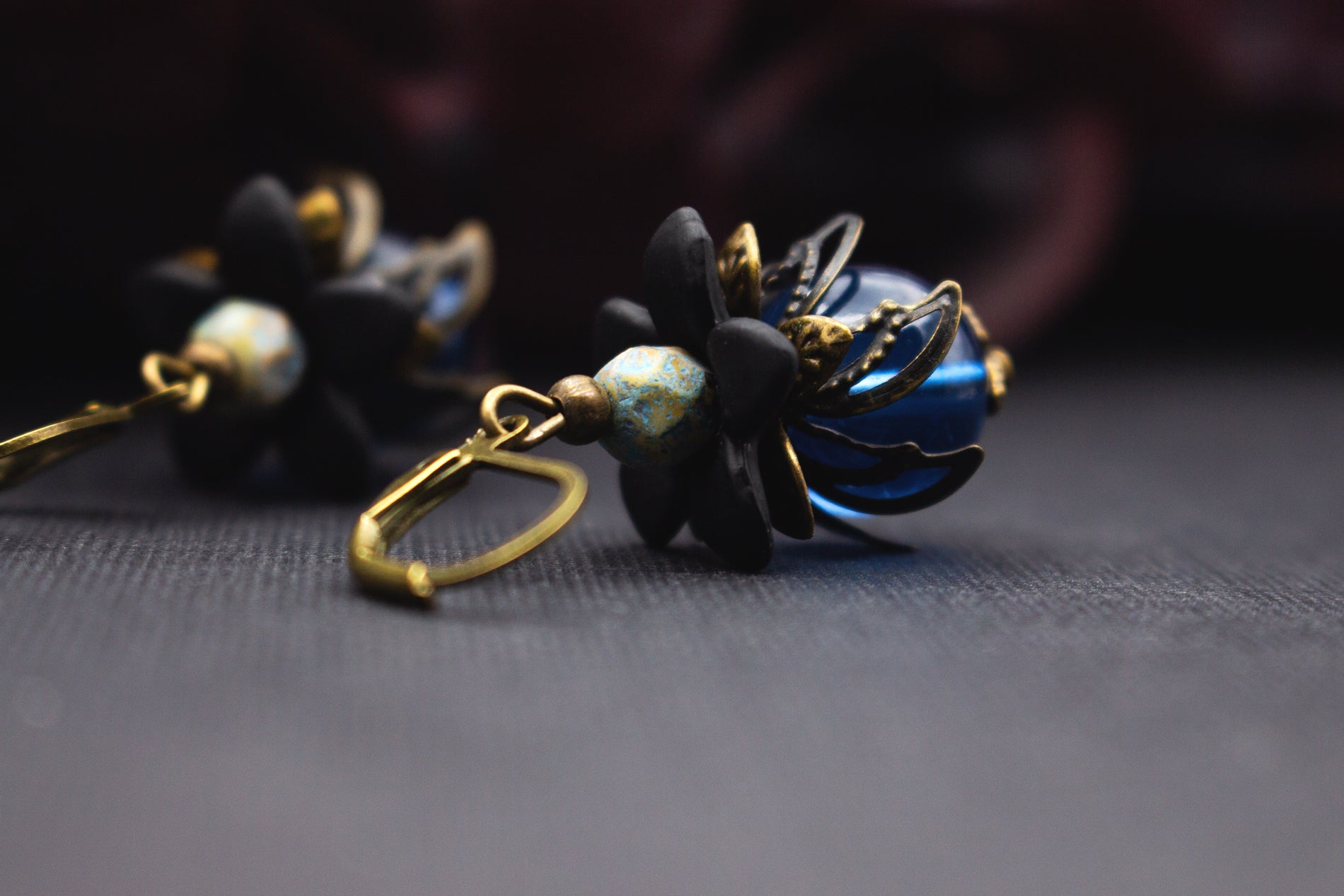 Vintage-Blumenohrringe in Blau und Schwarz mit metallischer Blütenkappe und Türkisdetail – elegantes Accessoire für Abendmode.