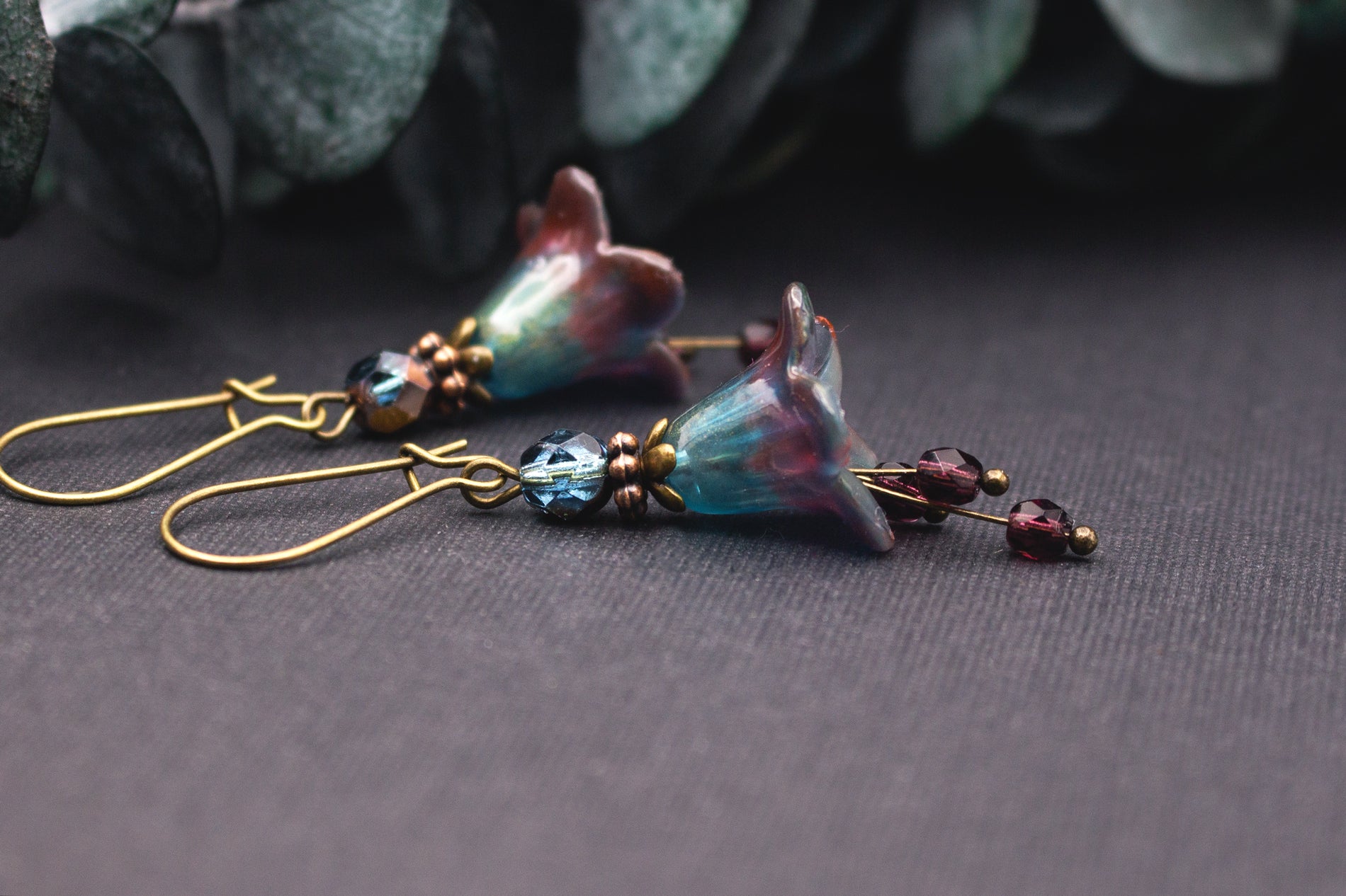 Handgefertigte Blütenohrringe in Dunkelrot und Petrolblau mit individueller Farbstruktur