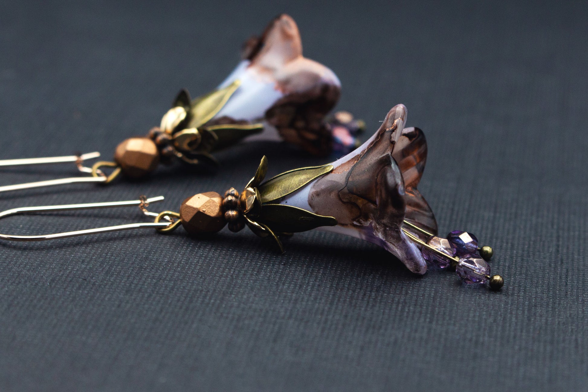 Detailaufnahme der handbemalten Glockenblumen in Flieder und Braun mit Glasperlen in Bronze und Gold