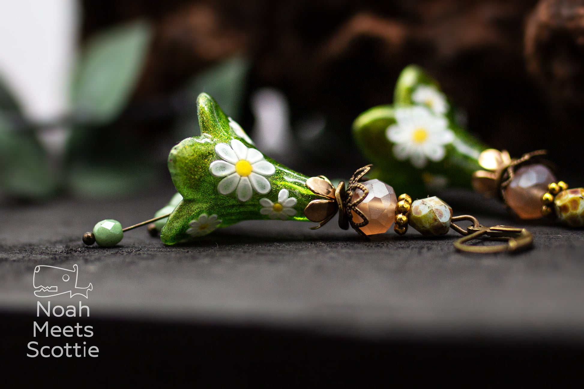 Große grüne Blumenohrringe mit handbemalten Blüten, weißen Margeriten und bronzefarbenen Details.