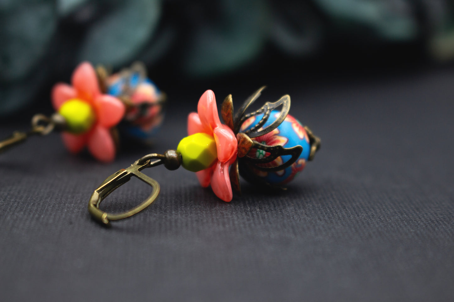 Bunte Blütenohrringe in Lachsrosa, Blau und Gelb mit Glasperlen und antik-bronzefarbenen Fassungen, verspielt und romantisch.