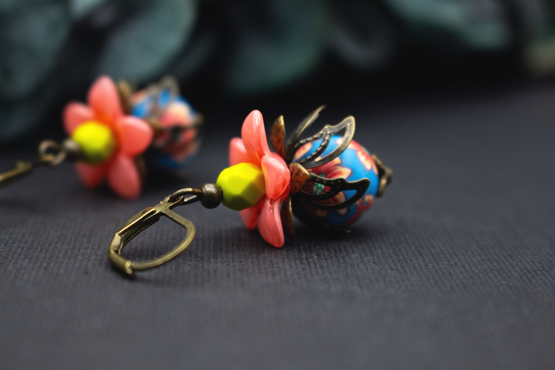 Bunte Blütenohrringe in Lachsrosa, Blau und Gelb mit Glasperlen und antik-bronzefarbenen Fassungen, verspielt und romantisch.