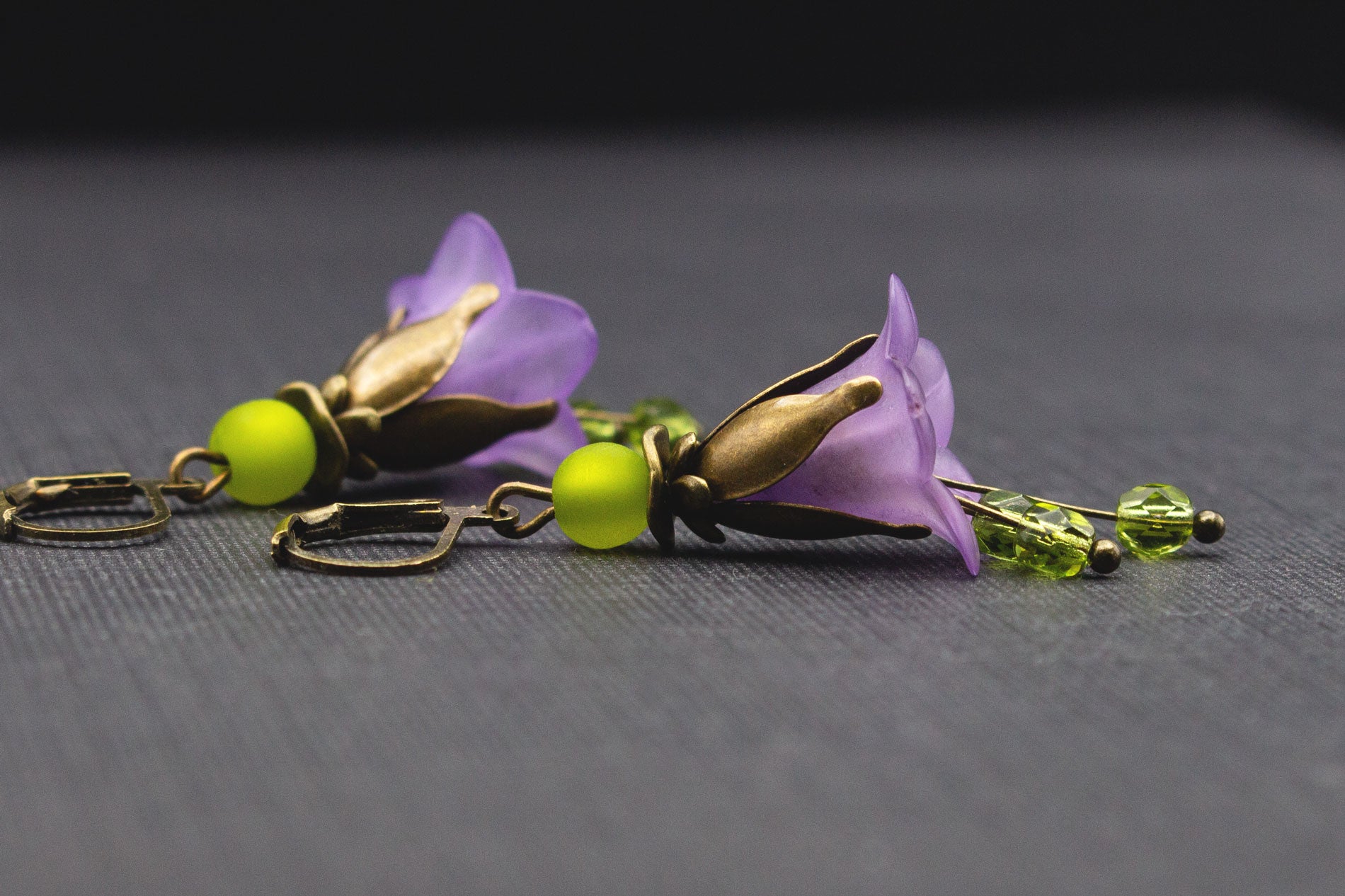 Detailaufnahme der Acryl-Glockenblumen in Lila mit olivgrünen Glas- und Polaris-Perlen