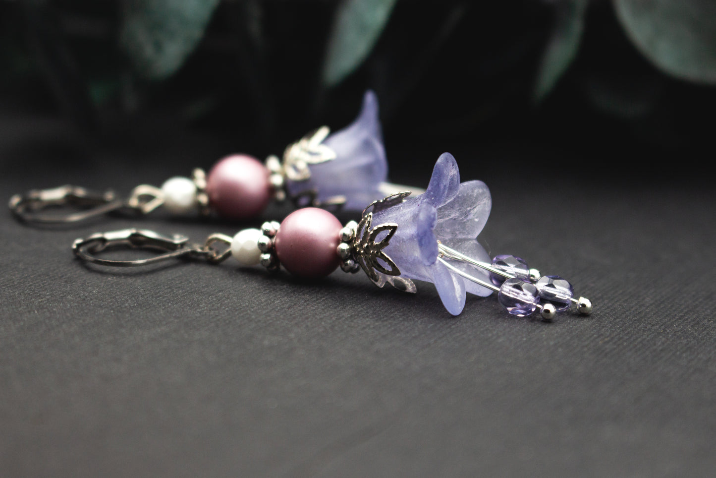 Lavendelfarbene Blütenglocken-Ohrringe mit Mauveperlen, weißen Akzenten und Silber – zarter Schmuck für Wintertage und festliche Looks.