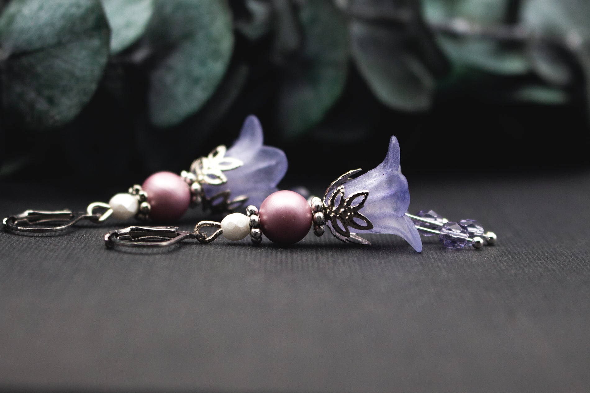 Glasperlenohrringe in Lila und Weiß mit silberner Blütenkappe – feiner winterlicher Ohrschmuck mit glitzernden Details.