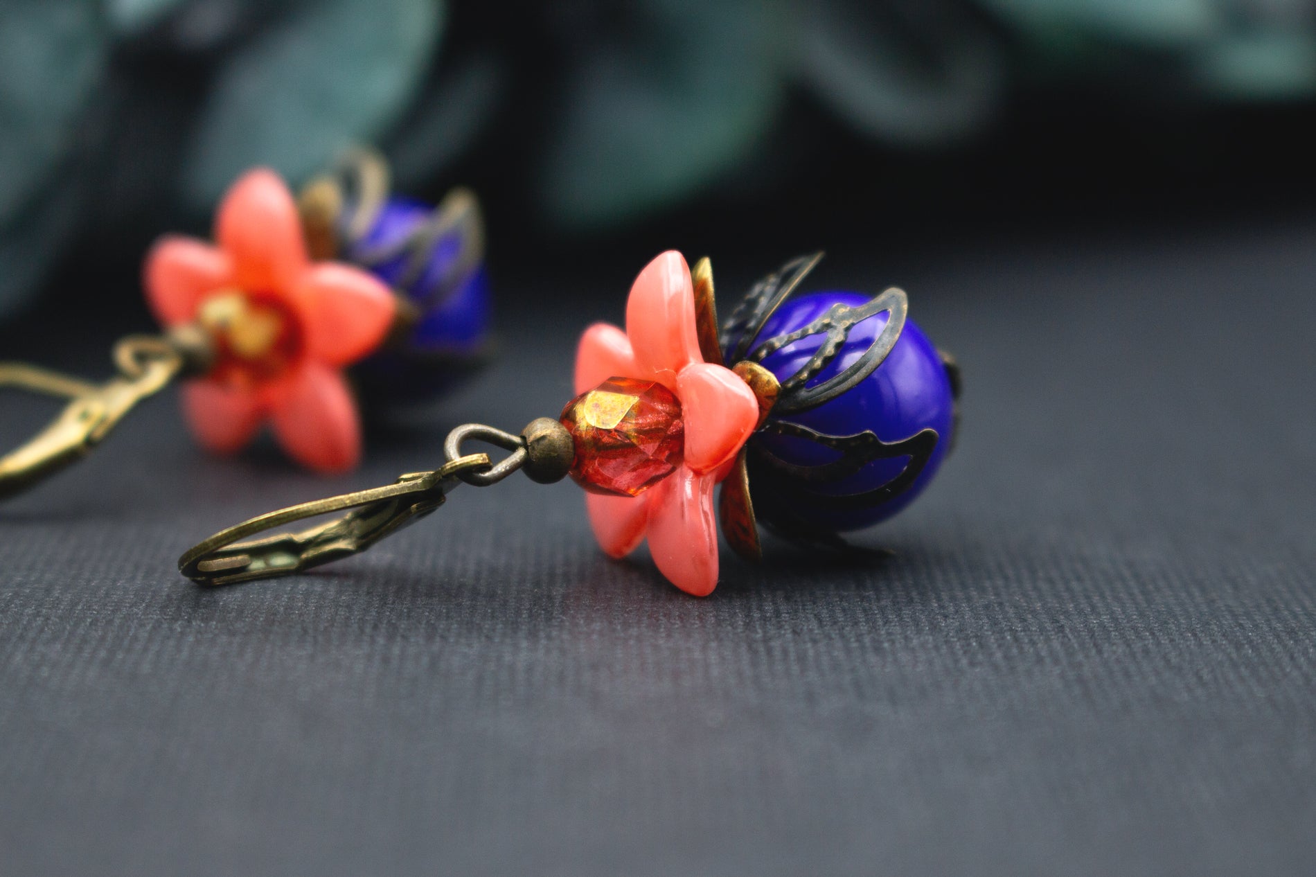 Blütenohrringe in Orange und Blau mit transparenter Glasperle und Bronze – farbintensiver Vintage-Schmuck mit lebendiger, ausdrucksstarker Farbwirkung