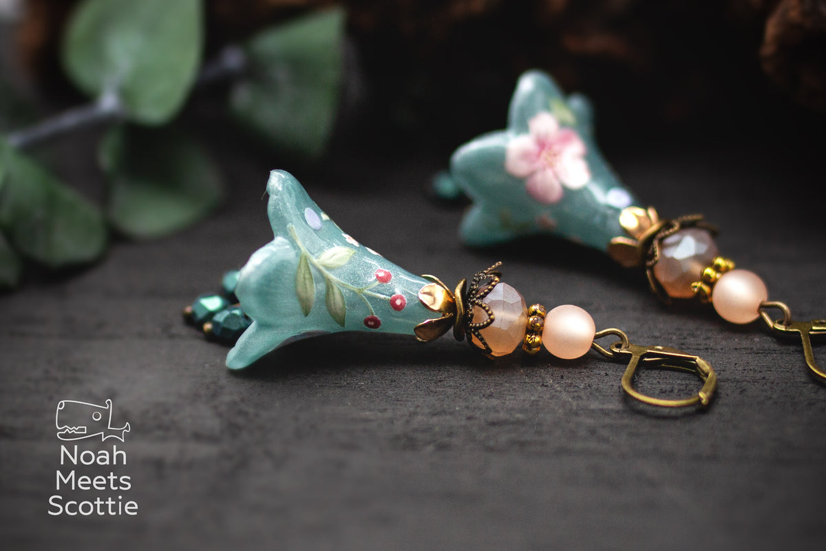Handgefertigte Blütenohrringe in Petrol mit rosa Blüten, roten Beeren und Glasperlen als floraler Vintage Schmuck