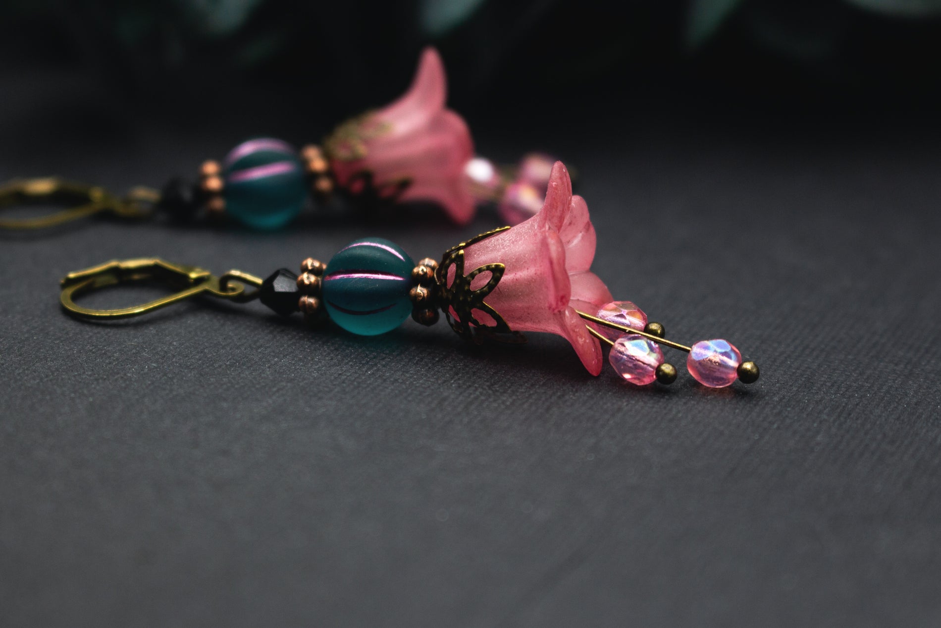 Florale Rosa-Petrol Ohrringe mit zarter Blütenglocke, facettierter Glasperle und bronzenen Details – feminine Ohrhänger mit sanfter Bewegung.