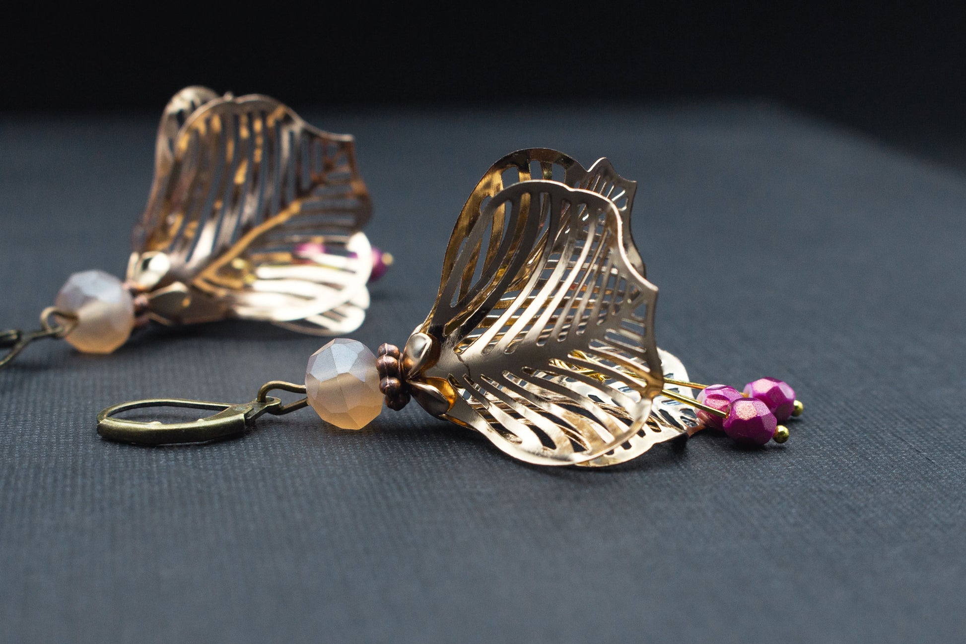 Detailansicht eleganter Blütenohrringe in Roségold mit filigranem Metall-Design