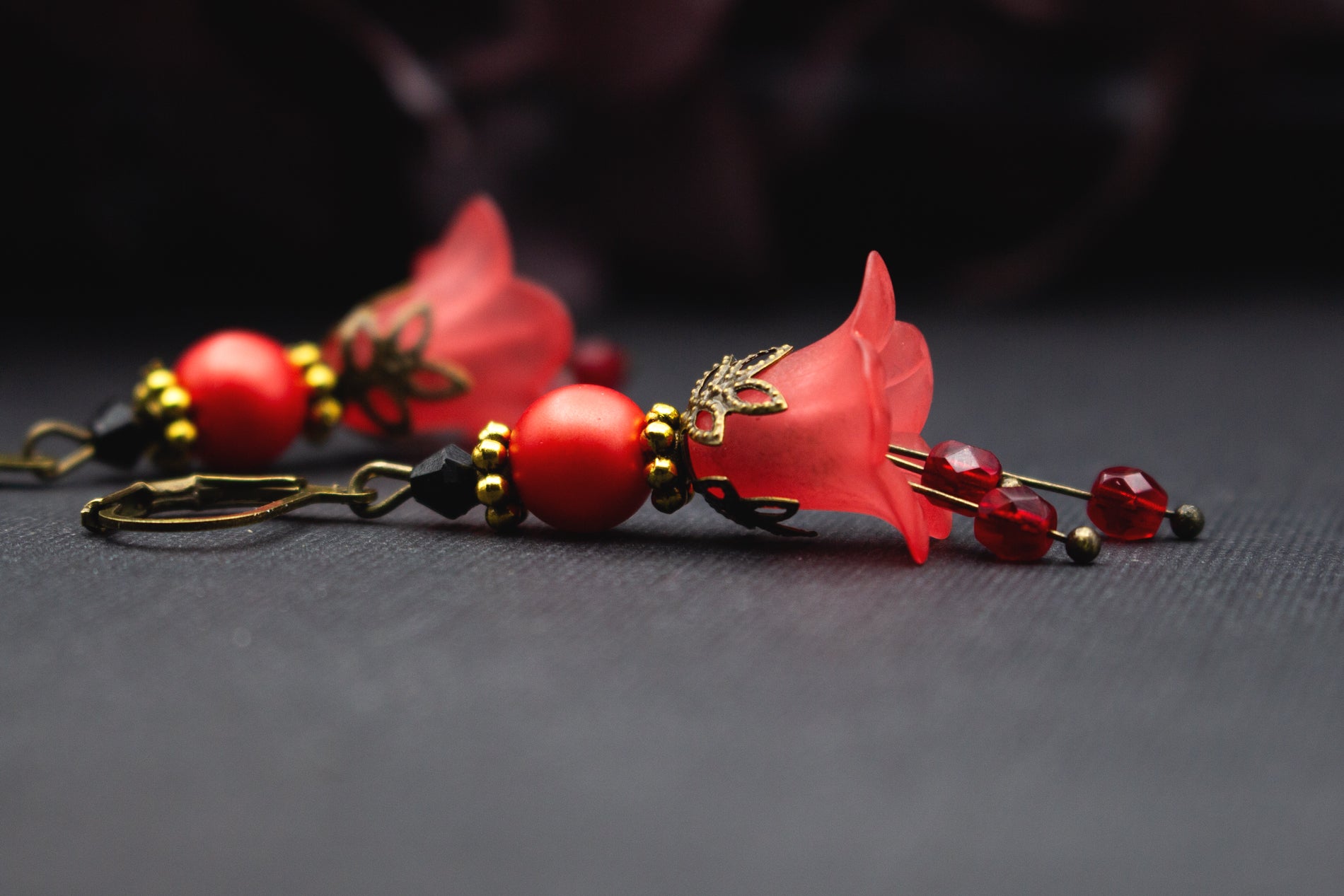 Rote Blütenohrringe mit goldenen Details und schwarzem Akzent, elegant