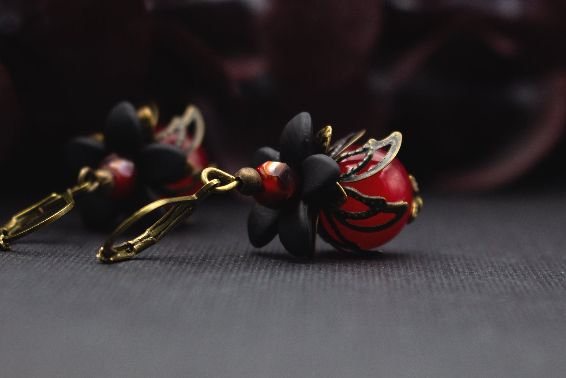 Ausdrucksstarke Rot-Schwarz-Ohrringe mit Blütenelementen aus Acryl, Glasperlen und Vintage-Bronze, perfekt als Geschenk oder Abendaccessoire.