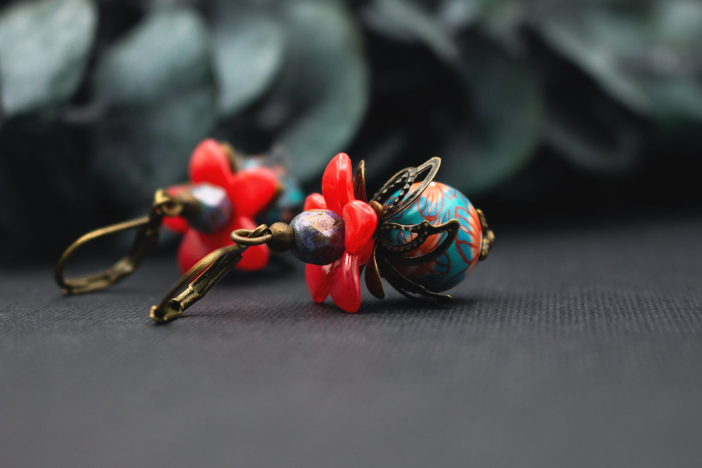 Handgefertigte Rot-Türkis Blütenohrringe mit facettierter Akzentperle – farbkräftiger floraler Schmuck für besondere Outfits.