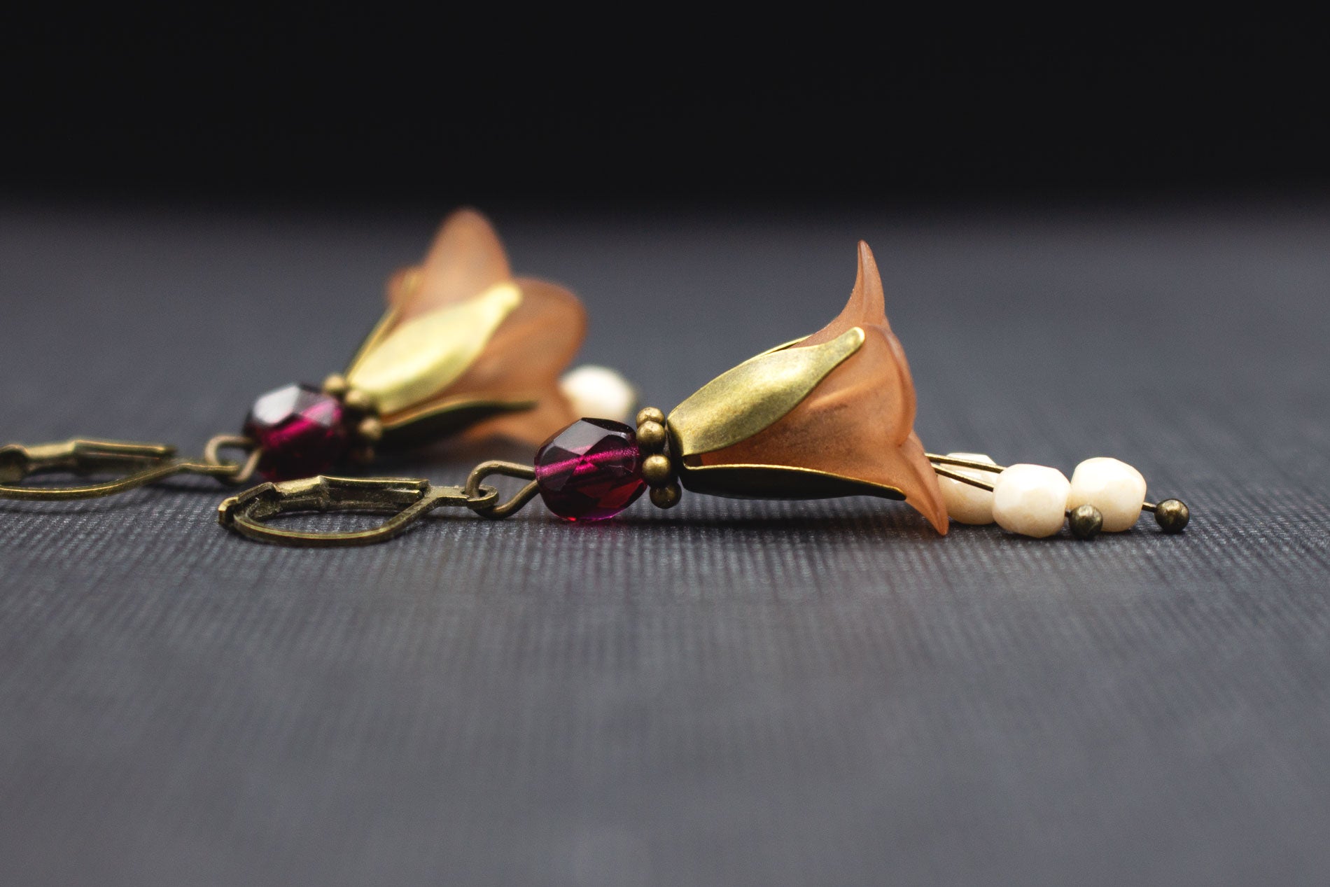 Seitenansicht von Blütenohrringen in Schokobraun mit Fuchsia- und Cremeweiß-Glasperlen