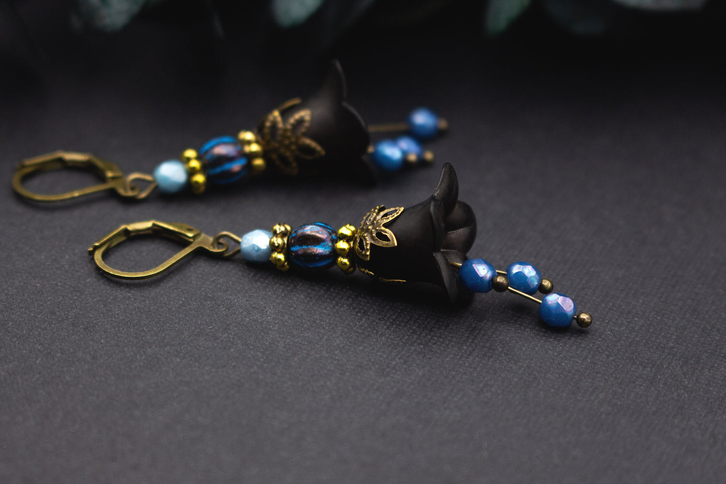 Florale Ohrringe in Schwarz und Blau mit marmorierter Glasperle und zarten Goldakzenten