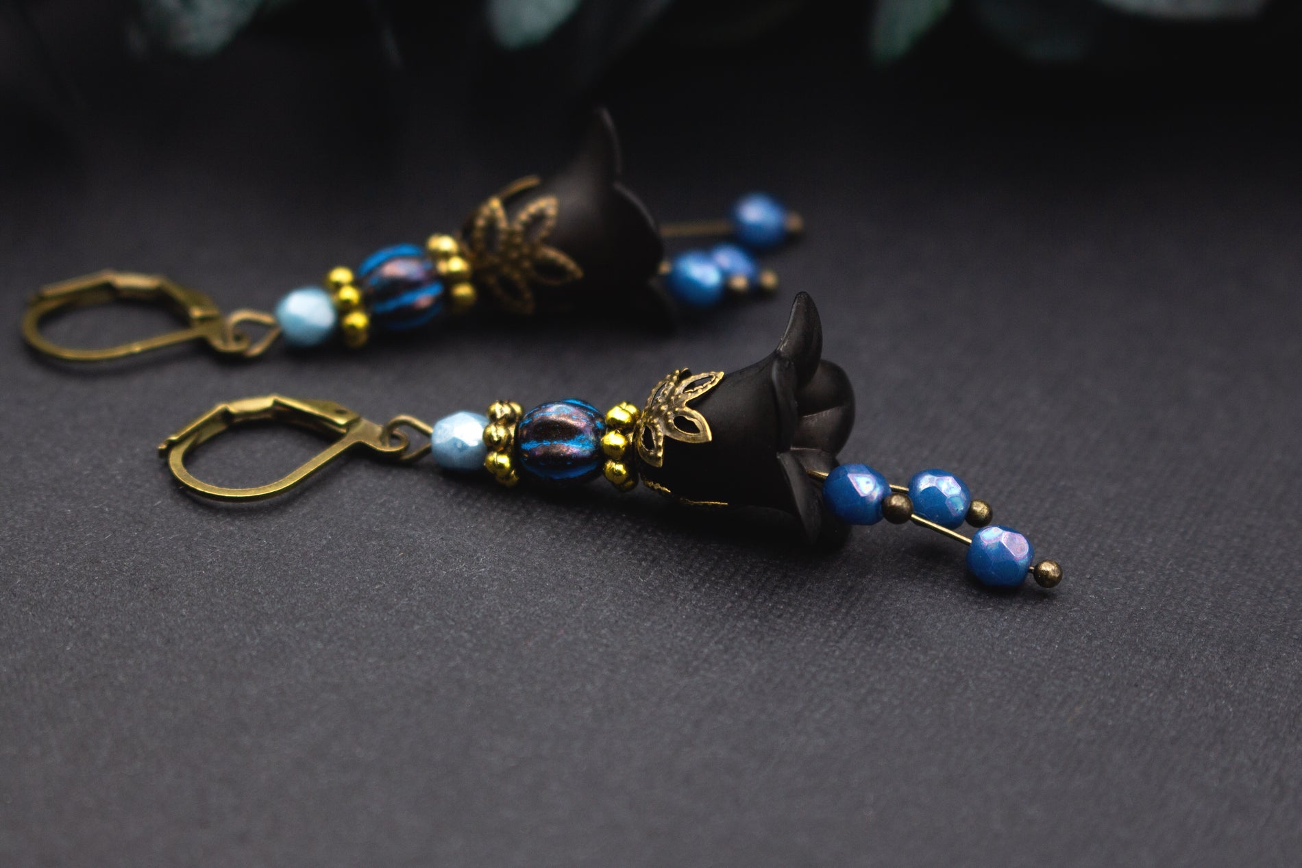 Florale Ohrringe in Schwarz und Blau mit marmorierter Glasperle und zarten Goldakzenten