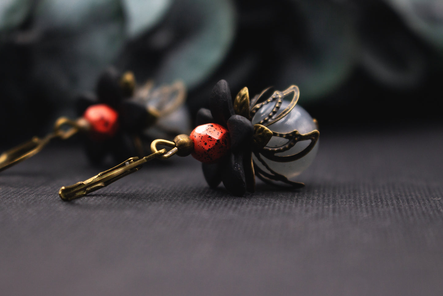 Schwarze Blütenohrringe mit grauer Glasperle und bronzefarbenen Details