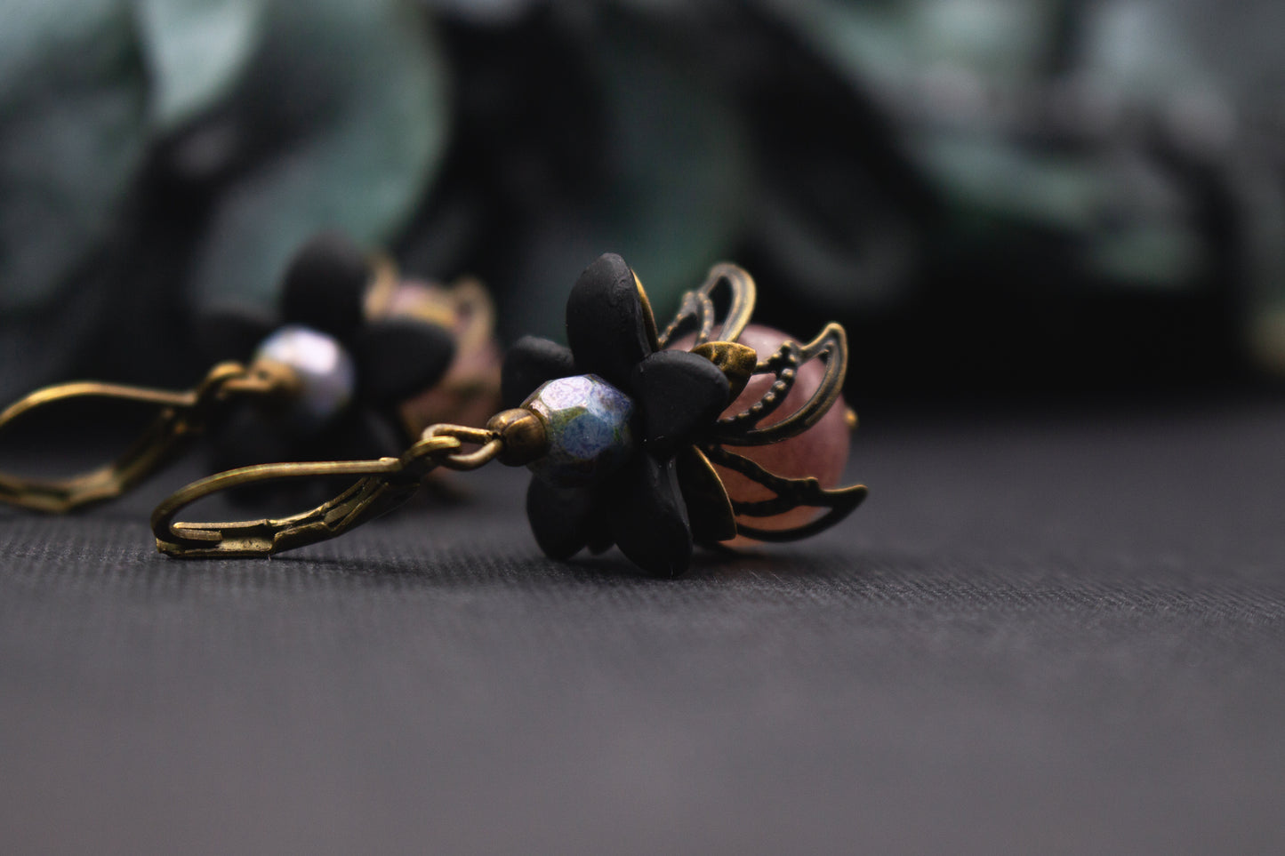 Handgefertigte Schwarz-Rosé Blütenohrringe mit irisierender Akzentperle – eleganter Ohrschmuck für moderne und festliche Looks.