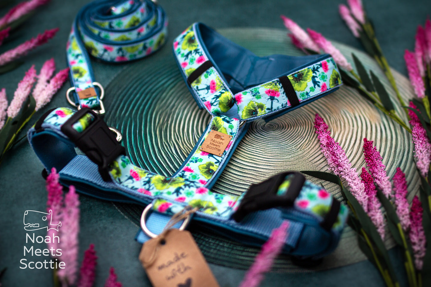 Detailansicht des Blumenmusters von Bloomadoodle mit pinken Blüten, grünen Blättern und geschwungenen Pflanzenranken