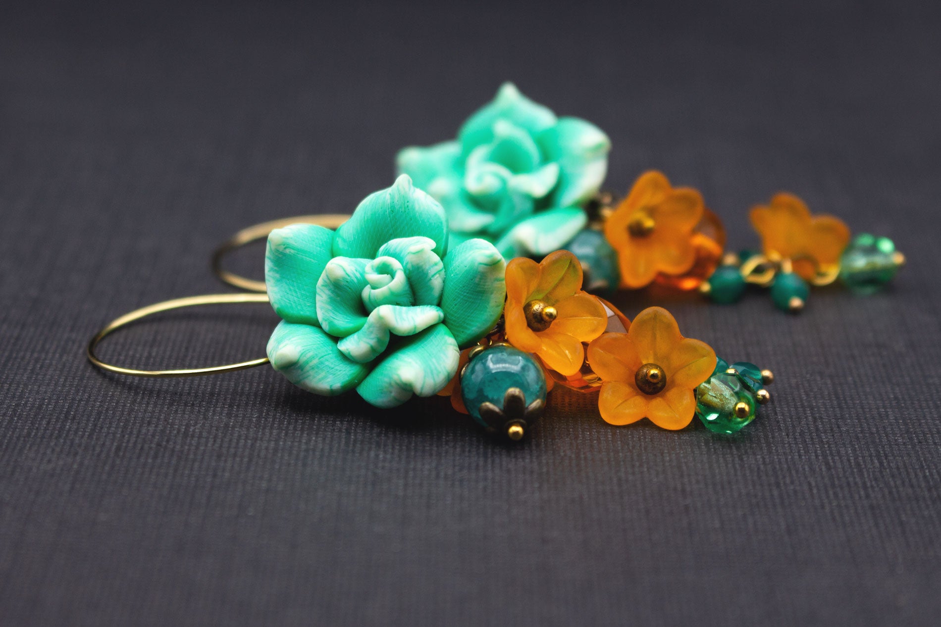 Seitenansicht Boho-Creolen mit Fimo-Blumen in Grün und Weiß, Perlen in Orange