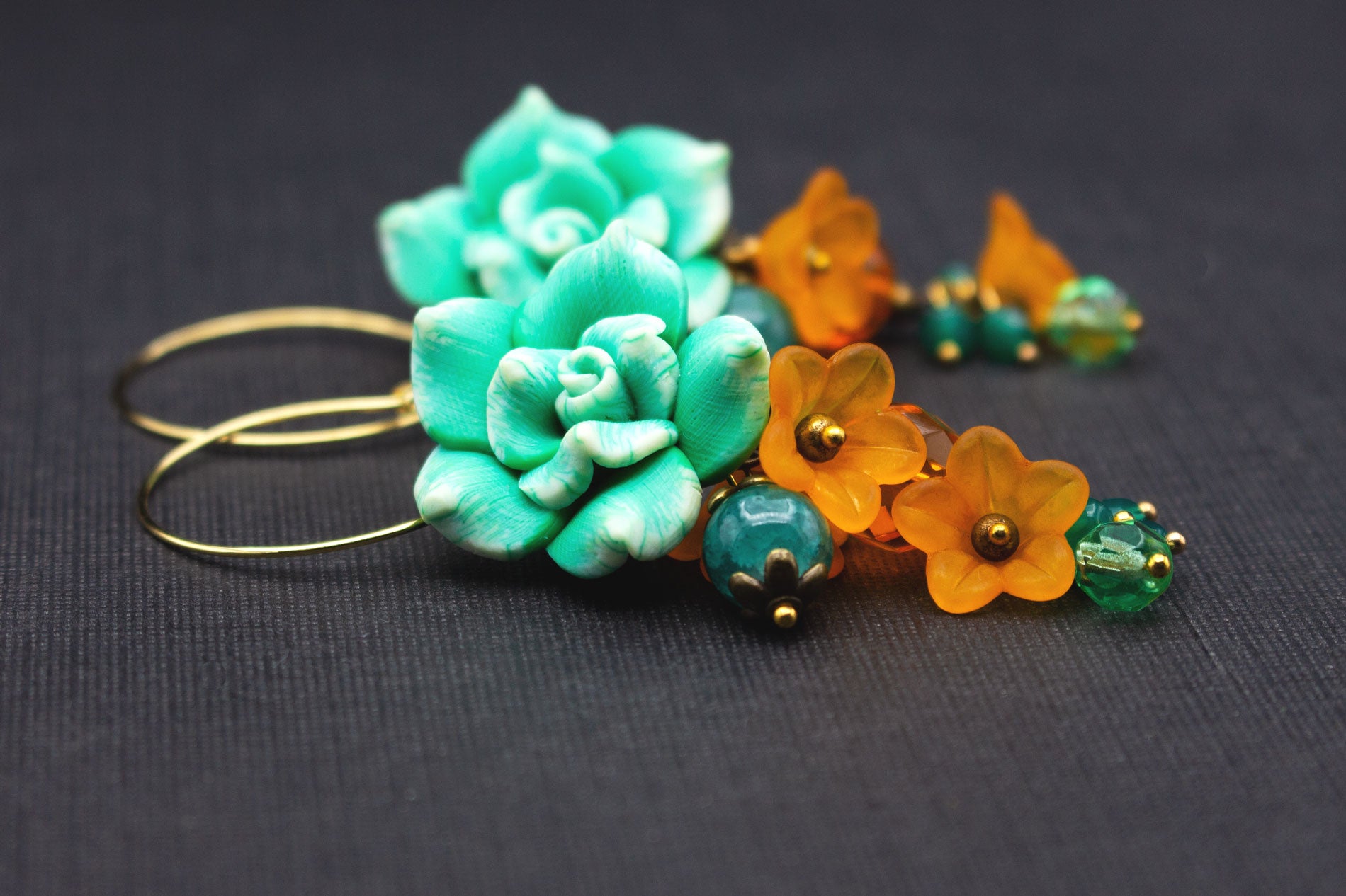 Detailansicht Boho-Creolen mit Fimo-Blumen in Grün und Weiß, Glas- und Acrylperlen in Orange